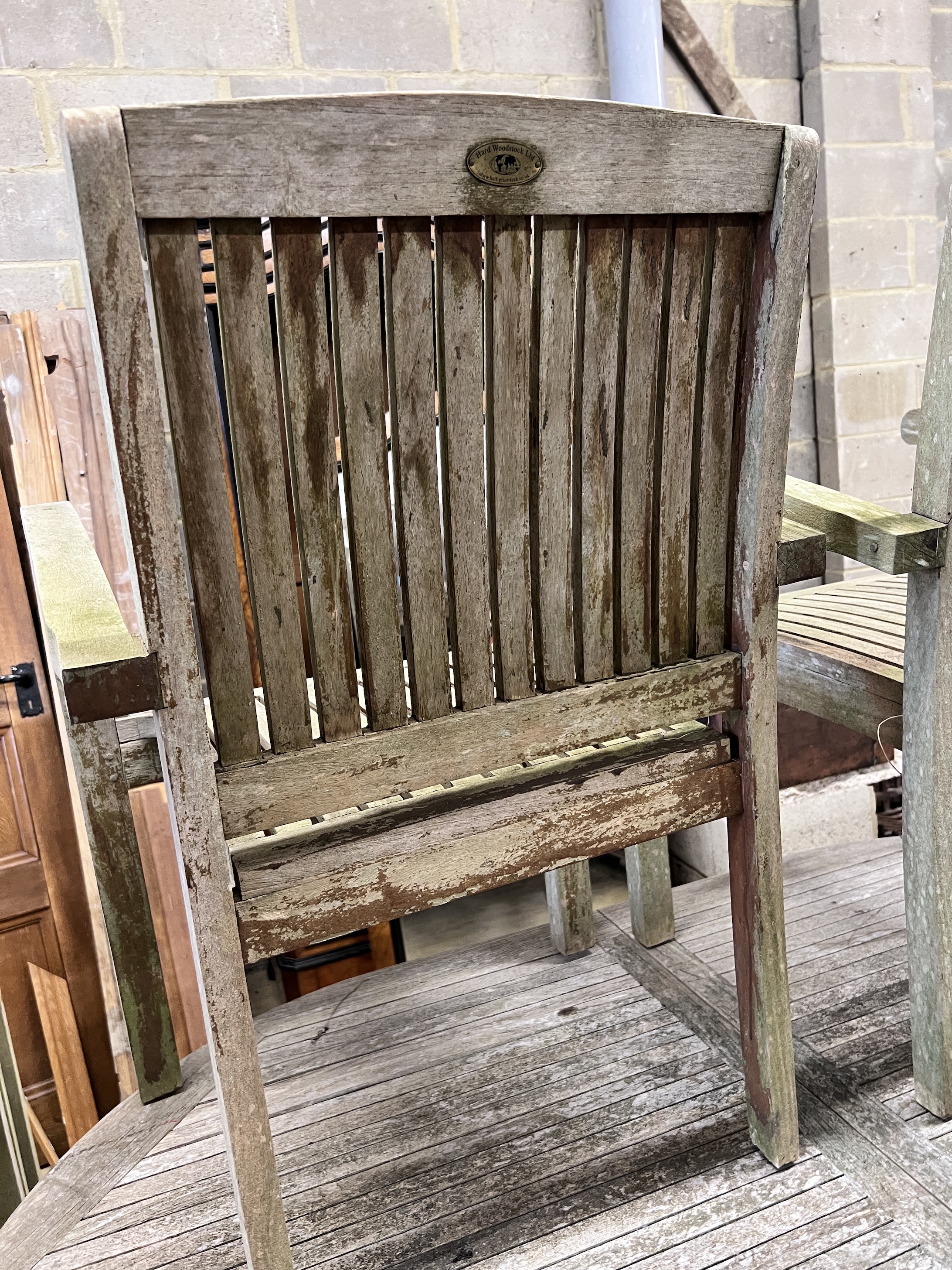 A Hard Woodstock Ltd. weathered teak extending garden table and eight matching stacking chairs